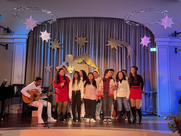 Die Freiwilligendienstleistenden singen in der Aula auf der Bühne