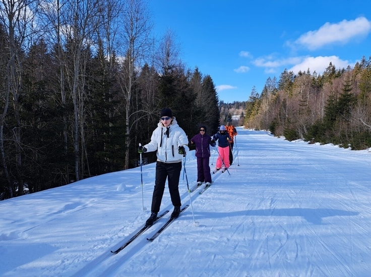 Mehrere Schülerinnen fahren hintereinander in der Loipe entlang eines Waldrandes. Video: Skifahren Finsterau